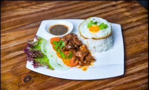 a plate of food with rice and vegetables on a table at Sweet Time Bungalows in Koh Rong Sanloem