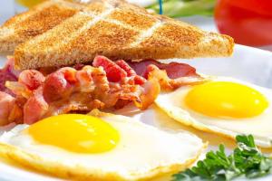 a breakfast sandwich with eggs and bacon on a plate at Sweet Time Bungalows in Koh Rong Sanloem