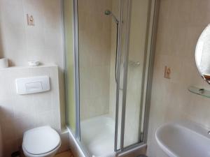 a bathroom with a shower and a toilet and a sink at Gaststätte & Pension Zum Türmer in Annaberg-Buchholz