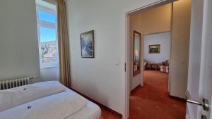 a bedroom with a bed and a large window at Seehotel Hubertus in Schluchsee