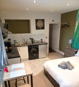a kitchen and living room with a bed and a table at Contemporary 1 bed studio for comfy stay in Wigan in Wigan