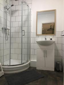Contemporary 1 bed studio for comfy stay in Wigan في ويغان: حمام مع دش ومغسلة ومرآة