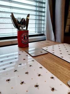 a cup of utensils sitting on top of a table at Contemporary 1 bed studio for comfy stay in Wigan in Wigan