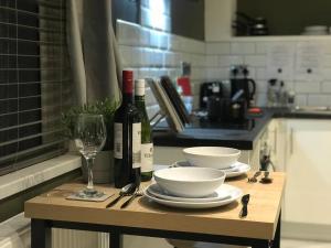 a table with two bottles of wine and a glass at Contemporary 1 bed studio for comfy stay in Wigan in Wigan