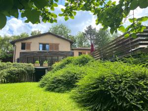 a house with a fence and bushes in the yard at Les Cabanons in Dardilly