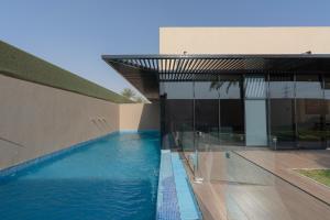 The One Hotel Resorts - Riyadh في الرياض: منزل به مسبح بجانب مبنى