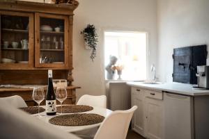 a kitchen with a table with two glasses of wine at Schlaf.Cabinet im Bio.Weingut (Lesehof seit 1424) in Krems an der Donau