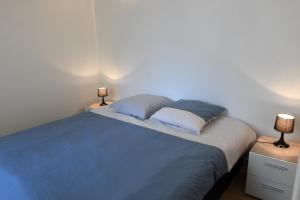 a bedroom with a bed with two lamps on it at La Belle Onde in Dieppe