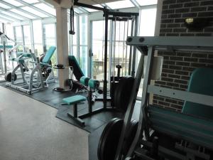 a gym with treadmills and chairs and a brick wall at Island Resort in Chincoteague