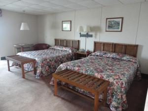a hotel room with two beds and a bench at Island Resort in Chincoteague