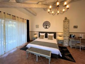 a bedroom with a large bed and a chandelier at Le Mas Carré Séguret in Séguret +43 photos