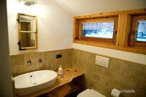 łazienka z umywalką, toaletą i oknem w obiekcie Bed & Breakfast Campaciol w Livigno +35 zdjęć