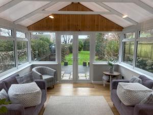 una sala de estar abierta con sofás y ventanas en Pass the Keys Charming 3br Listed Cottage in Historic Wigtown en Newton Stewart