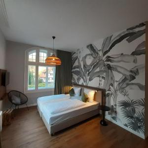 a bedroom with a bed and a wall mural at Hotel Müllers im Waldquartier in Bad Essen