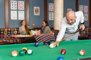 a man playing pool with a cue on a pool table at Hotel bei Tante ALMA in Mannheim
