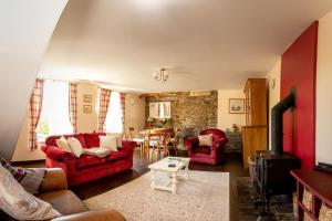ein Wohnzimmer mit roten Sofas und einem Holzofen in der Unterkunft Drovers Cottage in Tavistock