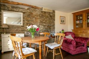 ein Esszimmer mit einem Holztisch und Stühlen in der Unterkunft Drovers Cottage in Tavistock