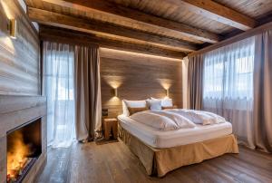 a bedroom with a large bed and a fireplace at Cima Dodici B&B - Apartments in Sesto