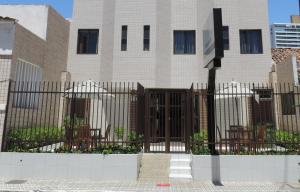 a fence in front of a building with chairs at Iracema Mar Hotel in Fortaleza