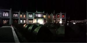 Hotel Skittsal Leh في ليه: مبنى مضاء في الليل مع أضواء