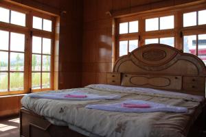 a bedroom with a bed with two towels on it at Hotel Skittsal Leh in Leh