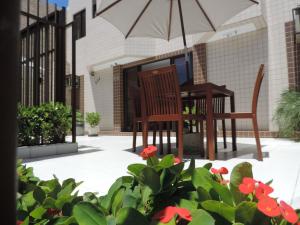 a patio with a table and chairs and flowers at Iracema Mar Hotel in Fortaleza