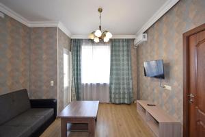 ein Wohnzimmer mit einem Sofa und einem TV in der Unterkunft Apartment for guest A3 in Yerevan