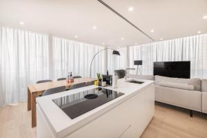 cocina blanca con sofá y mesa en Bay View Penthouse by Olala Homes, en Cascais