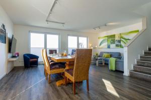 ein Esszimmer und ein Wohnzimmer mit Tisch und Stühlen in der Unterkunft Ferienhaus "Lee" in Heiligenhafen