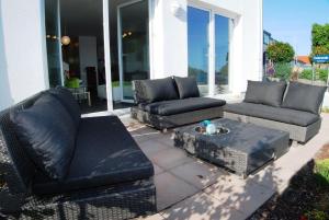 eine Terrasse mit 2 Sofas und einem Couchtisch in der Unterkunft Ferienhaus "Lee" in Heiligenhafen