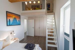 eine kleine Wohnung mit einem Bett und einer Treppe in der Unterkunft Ferienhaus "Lee" in Heiligenhafen