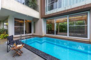 a swimming pool in the backyard of a house at StayVista's Bianco Villa - Hill-View Villa with Private Pool, Jacuzzi, Gym & Games Room in Lonavala
