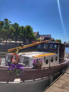 a boat with flowers on the side of the water at Historical boat Tu vėjo paklausk in Klaipėda