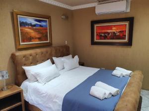 a bedroom with a bed with towels on it at Romans Rest Guest House in Carletonville +99 photos