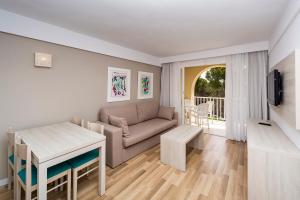 a living room with a couch and a table at Comitas Floramar in Cala Galdana