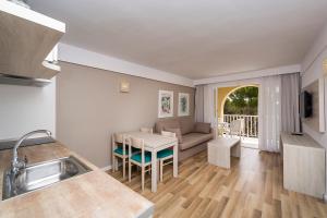 a kitchen and living room with a table and a couch at Comitas Floramar in Cala Galdana