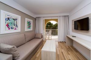 a living room with a couch and a tv at Comitas Floramar in Cala Galdana