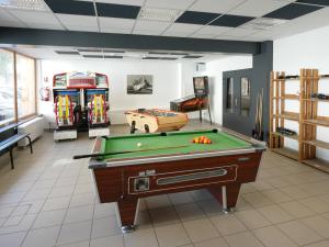 una habitación con mesa de billar y algunos juegos de arcade en ULVF Les Essertets, en Praz-sur-Arly