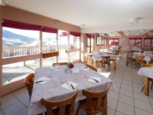 a restaurant with white tables and chairs and windows at ULVF Les Essertets in Praz-sur-Arly +35 photos