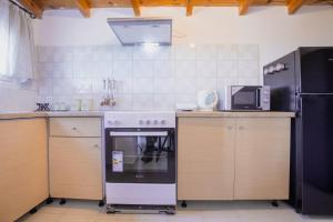 uma cozinha com um fogão e um frigorífico em At The Messinian's Bay em Velíka