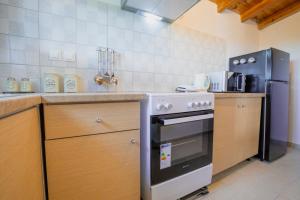 uma cozinha com um fogão e um frigorífico em At The Messinian's Bay em Velíka