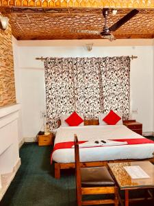 Un dormitorio con una cama grande con almohadas rojas. en Hotel Ashai, en Srinagar