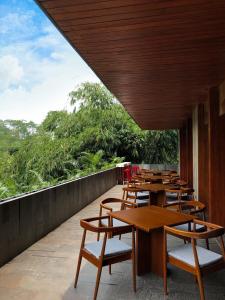 a row of wooden tables and chairs on a balcony at Hotel Dafam Wonosobo in Wonosobo
