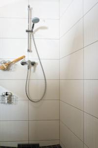 y baño de azulejos blancos con ducha. en Duenenpark-Heiligenhafen-Haus-Meerduene-Wohnung-2-Meertraum, en Heiligenhafen
