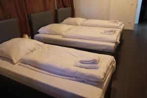 three beds in a room with towels on them at David's Hostel in Geesthacht