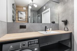 łazienka z umywalką i pralką w obiekcie Apart Park - Stylowe Studio 3 min od PLAŻY by Noclegi Renters w Świnoujściu