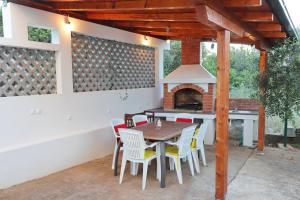 a patio with a table and chairs and a fireplace at Apartments Sergej in Drače