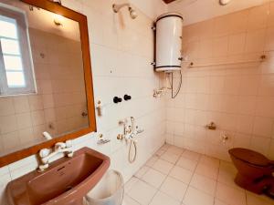 Un baño con lavabo, espejo e inodoro. en Hotel Ashai, en Srinagar 81 fotos más