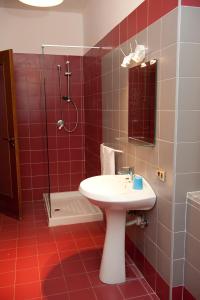 Baño de azulejos rojos con lavabo y ducha en Elena Residence, en Torchiara