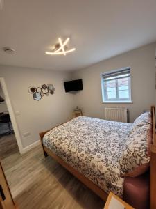 a bedroom with a bed and a tv on the wall at Cosy Cottage,The Paddock BARMSTON. NR BRIDLINGTON in Great Driffield